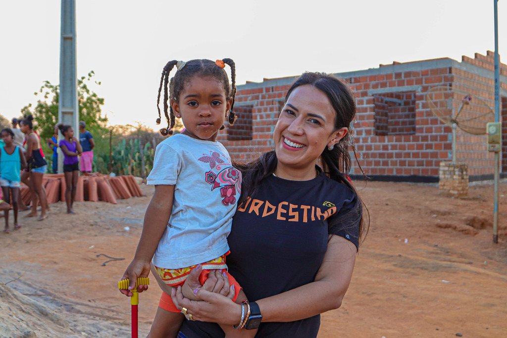 Talita Oliveira com uma menina no colo, em comunidade do interior da Bahia